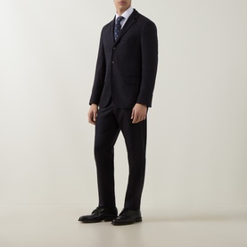 Model wearing Eleventy white casual shirt styled with navy suit, blue patterned tie, and black dress shoes.
