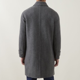 Model wearing Eleventy coat in Grigio Medio Melange, rear view showing back seam detail and cuffed sleeves, styled with navy trousers