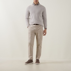 Model wearing Eleventy Cashmere Knitted Sweater in Sabbia E Bianco, styled with beige trousers, brown belt and suede trainers
