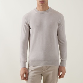 Model wearing Eleventy Cashmere Knitted Sweater in Sabbia E Bianco, long-sleeved shirt-style top, styled with beige trousers.