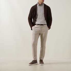 Model wearing Eleventy Cashmere Knitted Sweater in Sabbia e Bianco, styled with dark hooded jacket, taupe trousers and brown suede trainers.