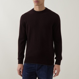 Model wearing Eleventy cashmere crew neck jumper in deep burgundy, paired with blue jeans