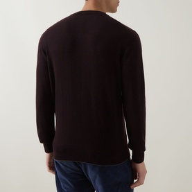Model wearing Eleventy cashmere crew neck in dark red, shown from the back, styled with navy trousers.