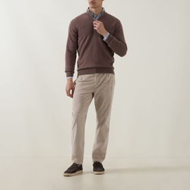 Model wearing Eleventy cashmere half zip in Moro E Sabbia, styled with a blue shirt and beige trousers with dark trainers.