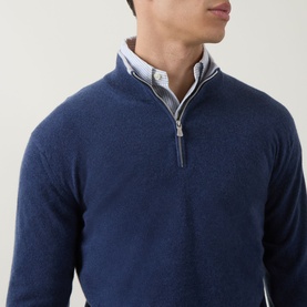 Model wearing Eleventy royal blue cashmere half-zip jumper, styled over a light grey checked shirt, close-up torso shot.