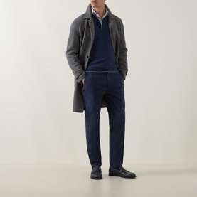 Model wearing Eleventy Royal Blue cashmere half zip, styled with grey wool overcoat and navy trousers, hands in pockets.