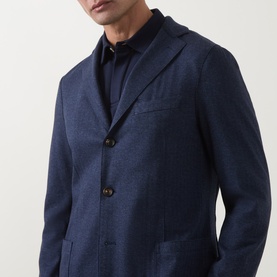 Model wearing Eleventy blue blazer jacket with notch lapels and patch pockets, styled with a dark navy shirt underneath.