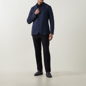 Model wearing Eleventy blue jacket with black trousers and dark loafers. Single-breasted, button-front style with a slim fit.