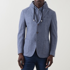 Model wearing Eleventy light blue cotton-wool blazer jacket with layered grey hoodie underneath and navy trousers.