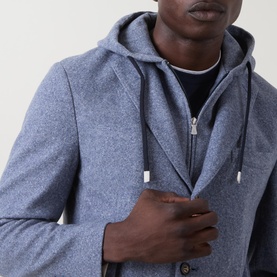 Model wearing Eleventy light blue cotton-wool hooded jacket, close-up of zip fastening and drawstring hood detail