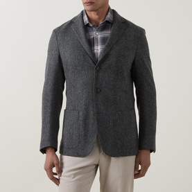 Model wearing Eleventy grigio medio melange wool-blend jacket with notch lapels, styled with plaid shirt and beige trousers.