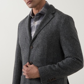 Model wearing Eleventy grey melange wool jacket with brown buttons, styled with plaid shirt, close-up detail view