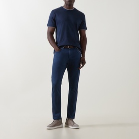 Model wearing Eleventy blue slim-fit jeans, styled with a navy tipped crew-neck tee and grey suede slip-on shoes