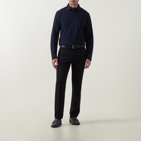 Model wearing Eleventy long-sleeve cotton polo in Blu Nuovo, styled with black tailored trousers and a black belt.