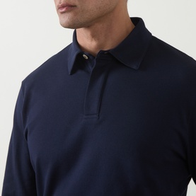 Model wearing Eleventy polo in Blu Nuovo, long-sleeve cotton piqu&eacute; with classic collar and button placket, close-up chest detail view