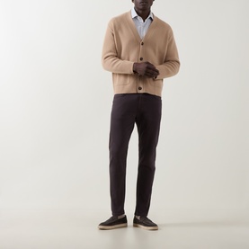 Model wearing Eleventy burgundy jeans styled with a camel cardigan, white shirt and dark suede loafers