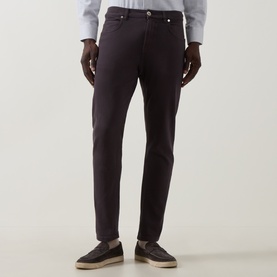Model wearing Eleventy burgundy slim-fit jeans in cotton-elastane, styled with grey shirt and dark loafers