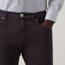 Model wearing Eleventy burgundy jeans, close-up of waist and front pocket detail, styled with a light grey shirt.