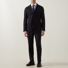 Model wearing Eleventy Single-Breasted Two-Piece Suit in blue wool-cashmere blend, styled with white shirt, patterned tie and black leather shoes.