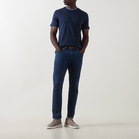 Model wearing Eleventy blue and light grey cotton T-shirt with crew neck tipping detail, styled with navy trousers and grey trainers.