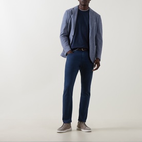 Model wearing Eleventy blue cotton T-shirt, styled with light grey blazer, navy trousers, brown belt and grey slip-on shoes.