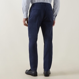 Model wearing Eleventy blue cotton trousers, rear view, slim tailored fit, styled with a white shirt and black leather shoes.