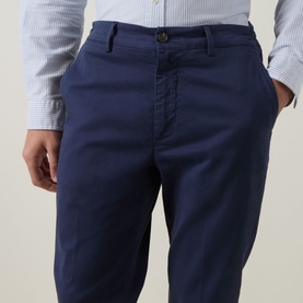 Model wearing Eleventy blue cotton chino trousers with slim fit, button fastening and side pockets, styled with a striped shirt