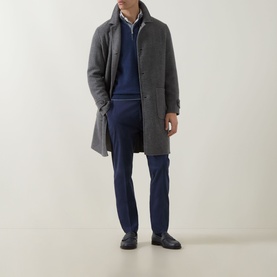 Model wearing Eleventy blue cotton-elastane trousers, styled with a grey wool overcoat, navy knit, and black loafers.