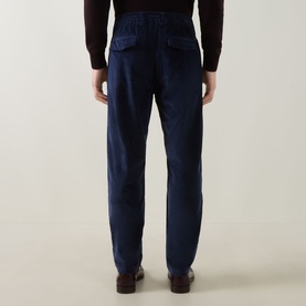 Model wearing Eleventy Drawstring Corduroy Trousers in blue, rear view showing flap pockets and relaxed fit, styled with dark knitwear.