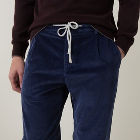 Model wearing Eleventy Drawstring Corduroy Trousers in blue, with white drawstring waistband detail, styled with a dark burgundy sweatshirt.