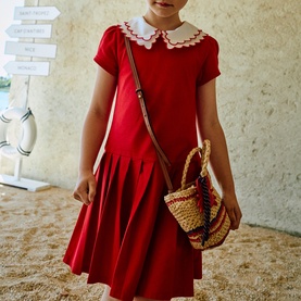 Model wearing Patachou red dress with white scalloped Peter Pan collar and short sleeves, styled with crossbody bag and wicker basket