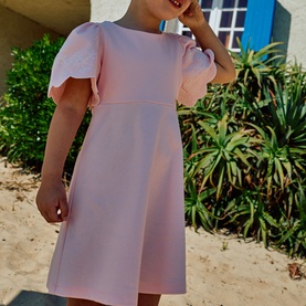 Model wearing Patachou Sweet Pink dress with scallop-edged flutter sleeves and A-line skirt, styled on a sunny outdoor setting.