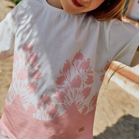 Model wearing Patachou bicolour print T-shirt with pink floral shadow print on white, small gold logo tab at hem