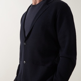Model wearing Slowear navy virgin wool cardigan with notch lapels and two-button fastening, styled with a navy crew-neck top.
