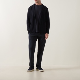 Model wearing Slowear navy virgin wool cardigan with matching trousers, black crew-neck tee, and beige slip-on shoes.