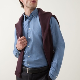 Model wearing Slowear Solid Single-Cuff Shirt in light blue with kent collar, styled with a burgundy knit gilet and dark trousers.