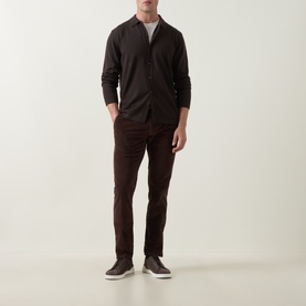 Model wearing Slowear brown casual trousers in slim fit, styled with a dark overshirt and grey tee, paired with dark trainers.