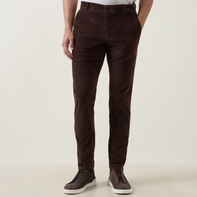 Model wearing Slowear brown casual trousers in slim fit with subtle texture, styled with grey trainers.