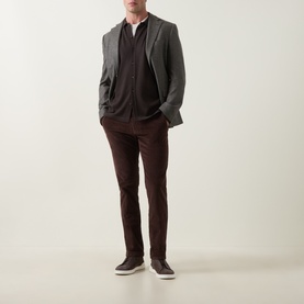 Model wearing Slowear brown casual trousers in slim fit, styled with grey blazer, dark knit and white shirt, paired with dark trainers.