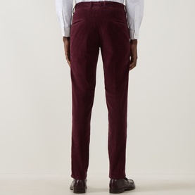 Model wearing Slowear burgundy corduroy casual trousers, rear view, styled with a white shirt and brown leather shoes.