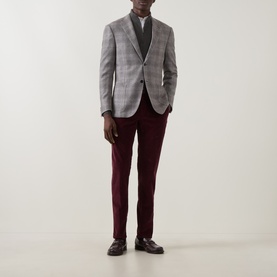 Model wearing Slowear burgundy casual trousers in cotton blend, styled with grey check blazer and dark loafers.