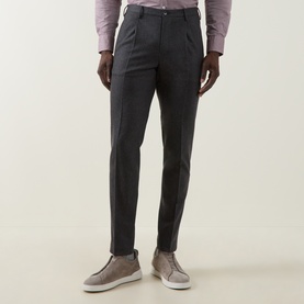 Model wearing Slowear grey formal trousers in slim fit with front pleats, styled with a pink shirt and grey suede loafers.