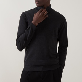 Model wearing Slowear charcoal half zip knit in virgin wool, styled with matching dark trousers, ring visible on hand.
