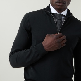 Model wearing Slowear green wool half-zip knit, styled with white shirt and dark tie, close-up chest shot showing zip detail