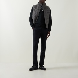 Model wearing Slowear green wool half zip, styled with a quilted gilet and black tailored trousers with leather shoes.