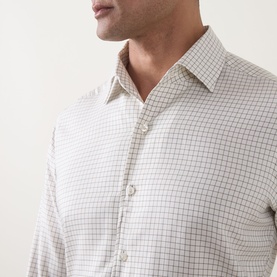 Model wearing Strellson black suit trousers, styled with a white grid-check button-up shirt, close-up detail shot.