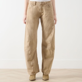 Model wearing Free People Oat Latte wide-leg jeans in 100% cotton, styled with tan ankle boots. Relaxed barrel fit with worn-in detailing.