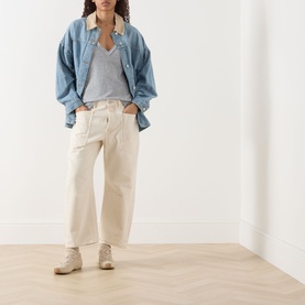 Model wearing Free People We The Free Minimalist Moxie Low-Rise Barrel Jeans in Dusty Roads, styled with denim shirt and grey top