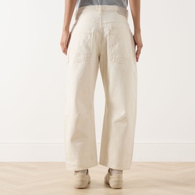 Model wearing Free People We The Free Minimalist Moxie Low-Rise Barrel Jeans in Dusty Roads, showing rear patch pockets and wide-leg silhouette