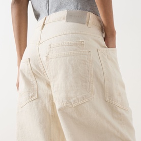 Model wearing Free People We The Free Minimalist Moxie Low-Rise Barrel Jeans in Dusty Roads, showing patch pockets and relaxed barrel-leg silhouette